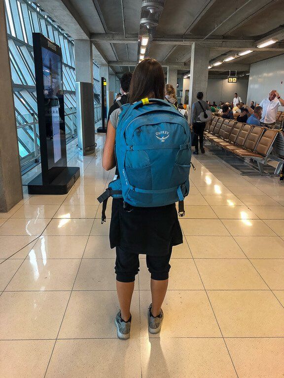Kristen wearing her osprey farpoint 40 in airport terminal compact and lightweight backpack