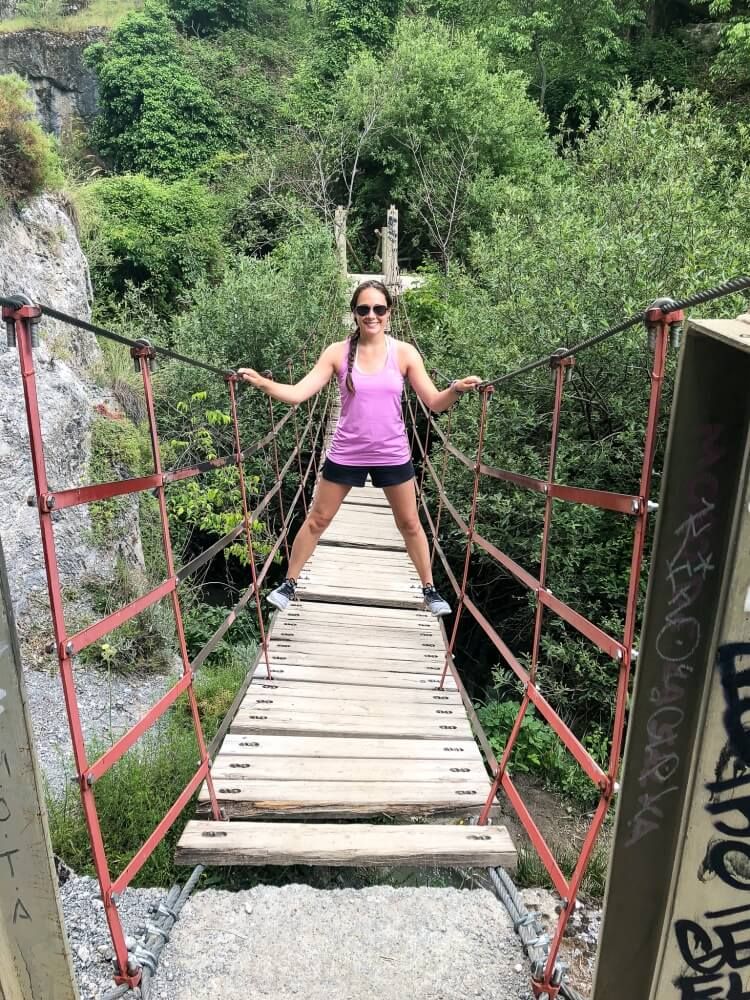 Kristen standing on hanging bridge on los cahorros hiking trail