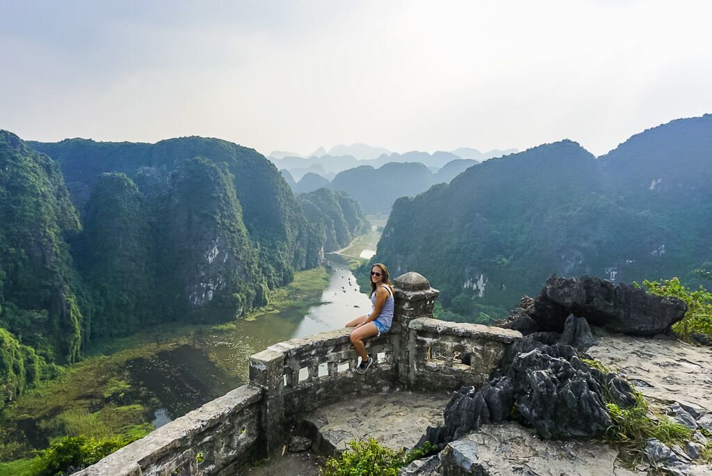 Woman sitting on the edge of a railing  in Tam Coc Vietnam