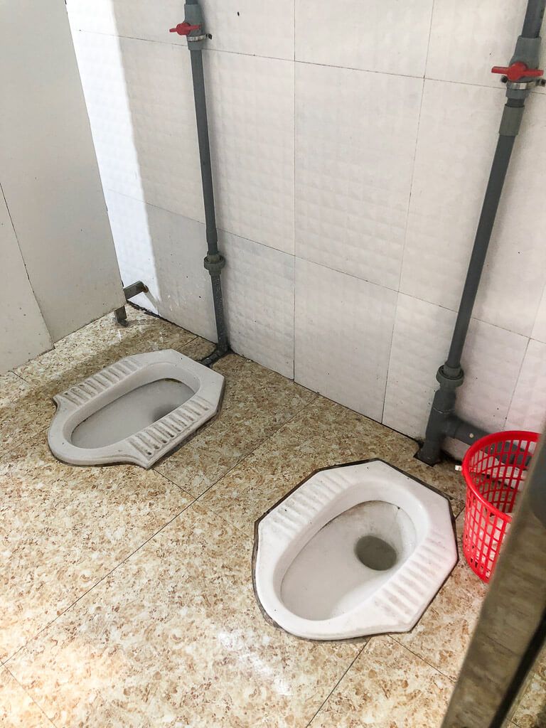 Two squat toilets at a service station in Vietnam