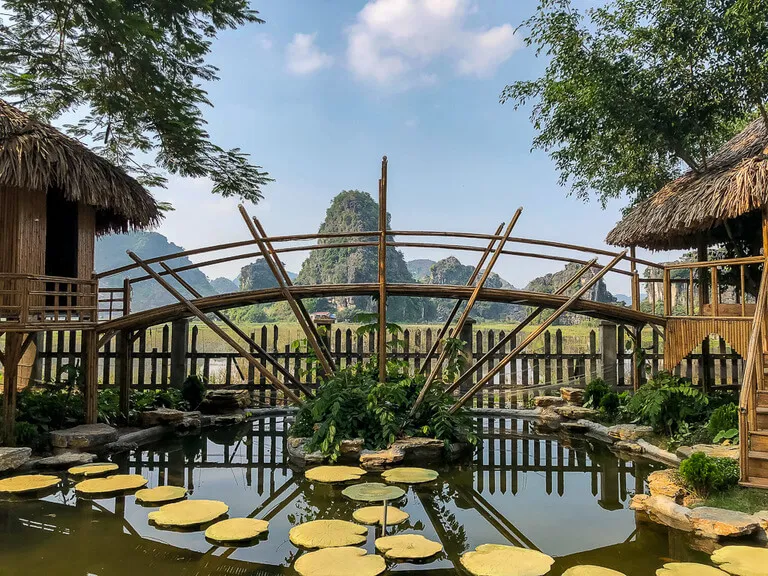 Bamboo hut and pond with stone Lillies near the entrance to Mua Cave or Khu Du Lich Hang Mua Peak