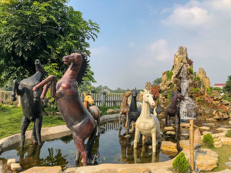 Wooden horses on display in a water feature at Khu Du Lich Hang Mua Peak near Ninh Binh Vietnam
