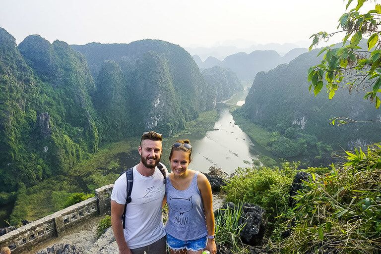 Man and women posing for a photo with the river and mountains in background
