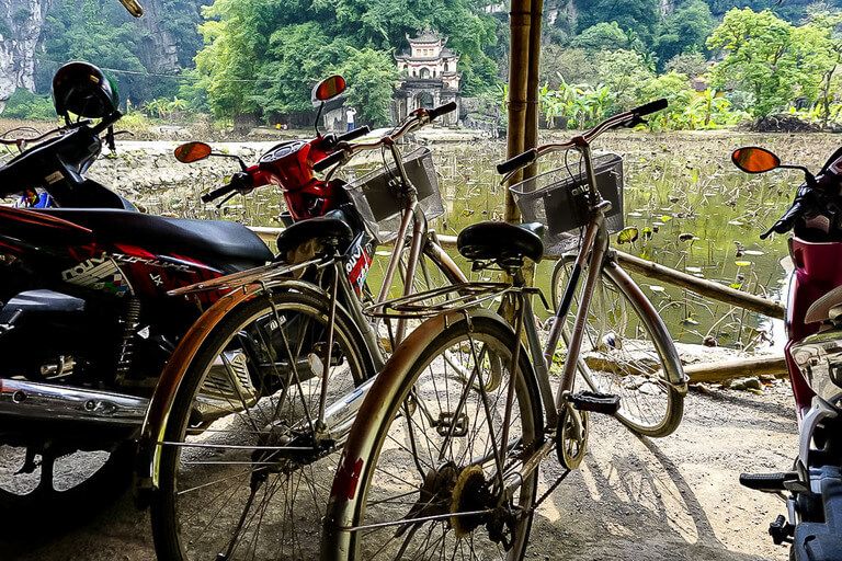 Two bikes parked in a shed at the entrance to Bich Dong pagoda