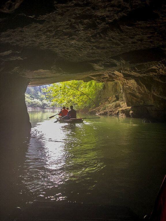 boat exiting cave to sunshine and beautiful landscapes