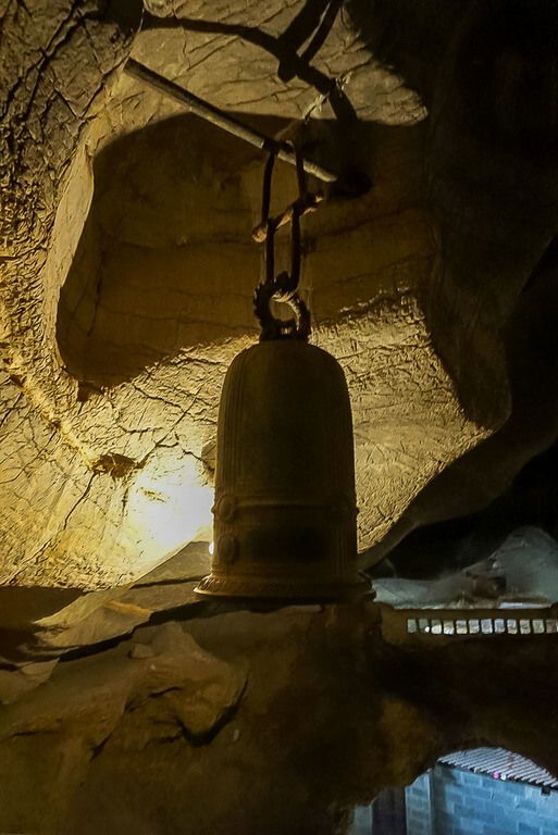 A large bronze bell with engravings inside Bich Dong cave