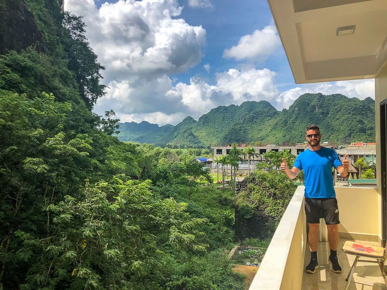Man on a hotel balcony in Phong Nha with spectacular view of the surrounding green hills