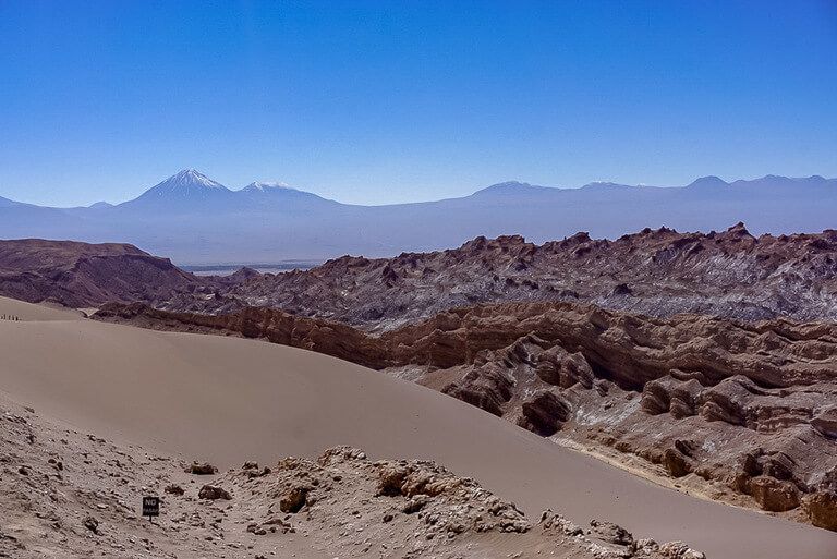 spectacular views of sand dune and jagged red rocks in valle de la luna
