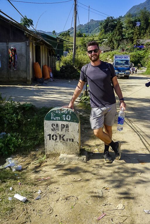 Mark leaning on sapa stone sign end of 2 days trekking vietnam
