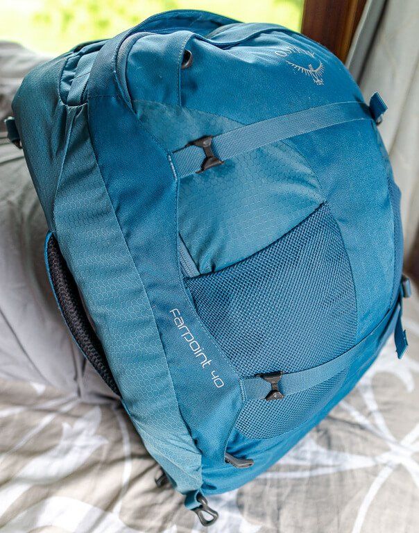 Front side view of blue Osprey Farpoint 40 backpack filled to show its capacity