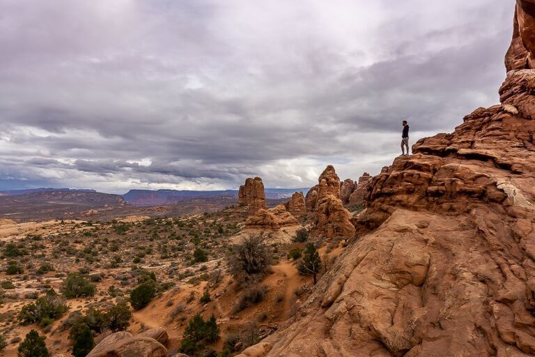 Hiker stood on rocks looking at the distant horizon