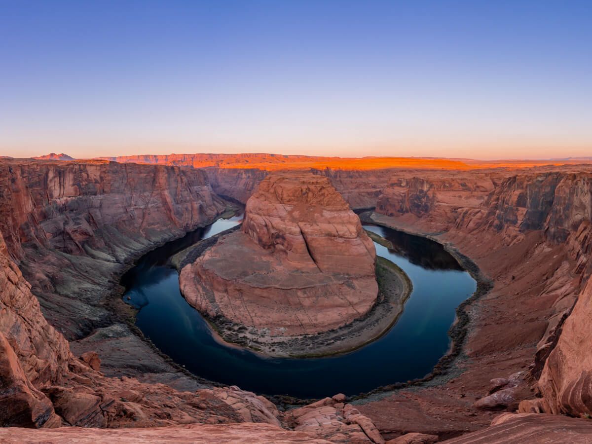 Stunning sunrise over Horseshoe Bend in Page Arizona purple sky and orange sandstone rocks being lit up by the morning sun horseshoe shaped bend in the Colorado River is immense