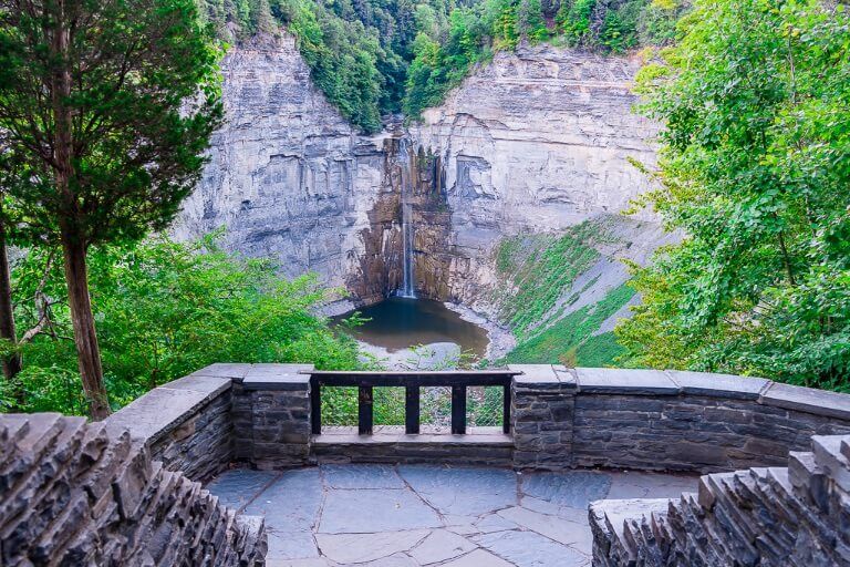 Taughannock Falls State Park overlook view of Taughannock Waterfall in the distance beyond stone staircase New York waterfall tallest single drop east of Rockies