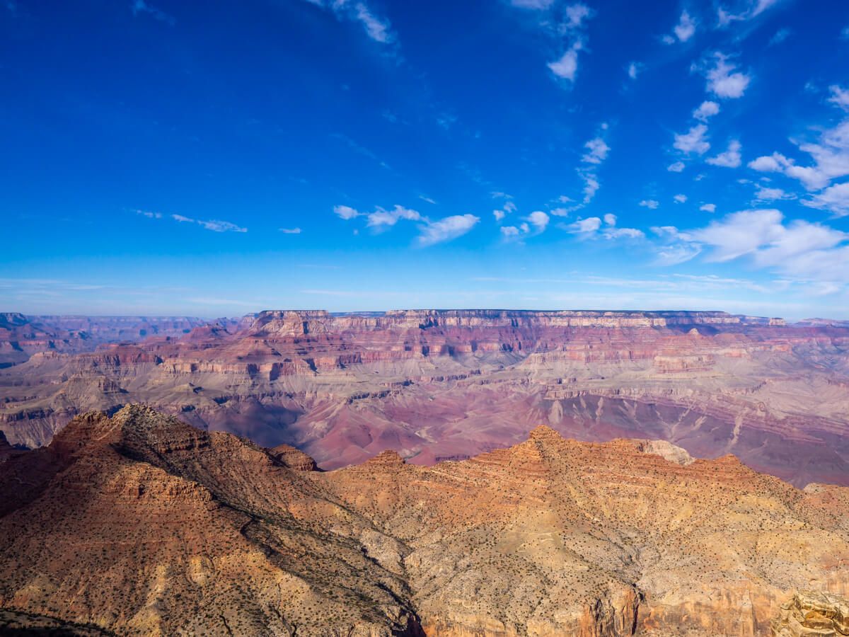 Grand Canyon South Rim One Day Two Days Itinerary Things To Do by Where Are Those Morgans spectacular view over the deep canyon with colorful sandstone and blue sky above