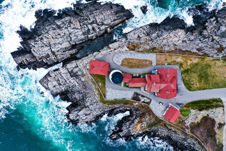 Birds eye view drone photography of portland lighthouse in maine awesome picture of america turquoise waters waves crashing and entire lighthouse plot