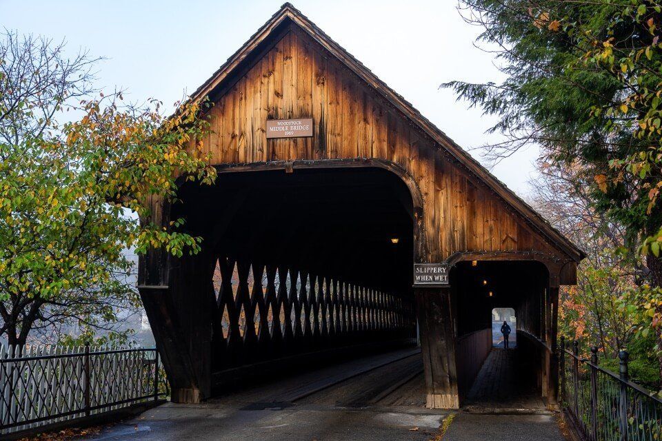Beautiful covered bridge in downtown woodstock vermont man silhouetted against entrance to pedestrian walkway