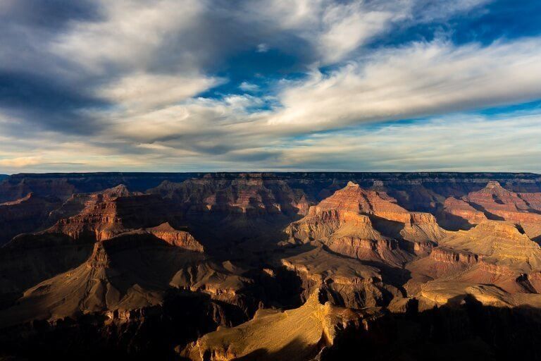 Stunning Grand Canyon viewpoint close to sunset with epic shadows cast across the canyon and blue sky
