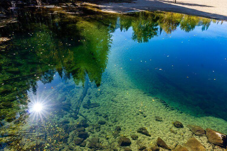 Starburst of the sun reflecting in deep and shallow water in california