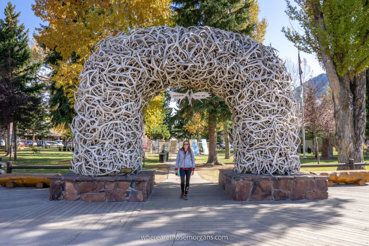 Tourist stood underneath an arch made of elk antlers in the middle of a town in Wyoming