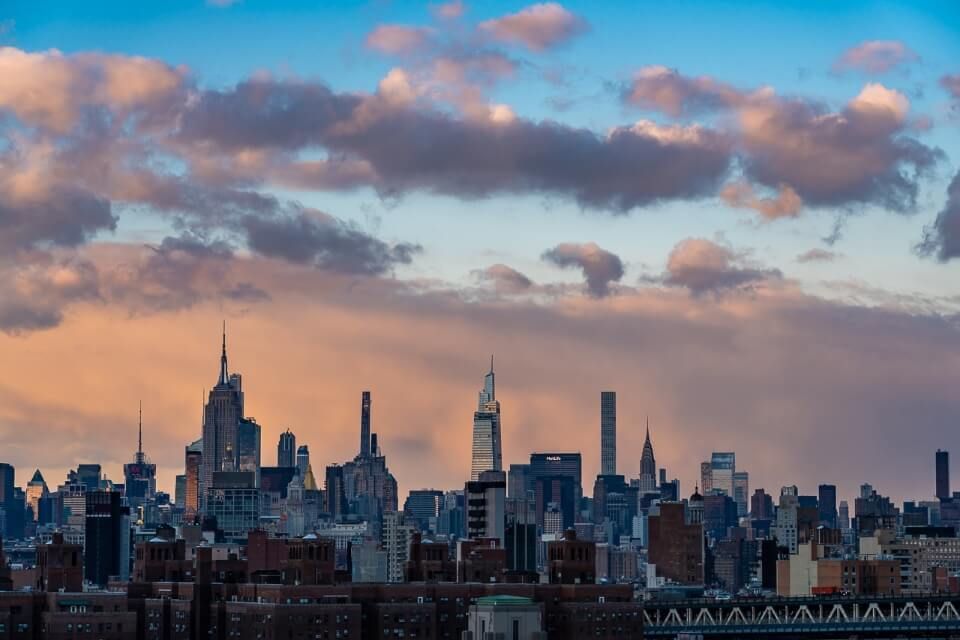 Midtown Manhattan from at sunset with stunning colors and puffy clouds over New York City photography