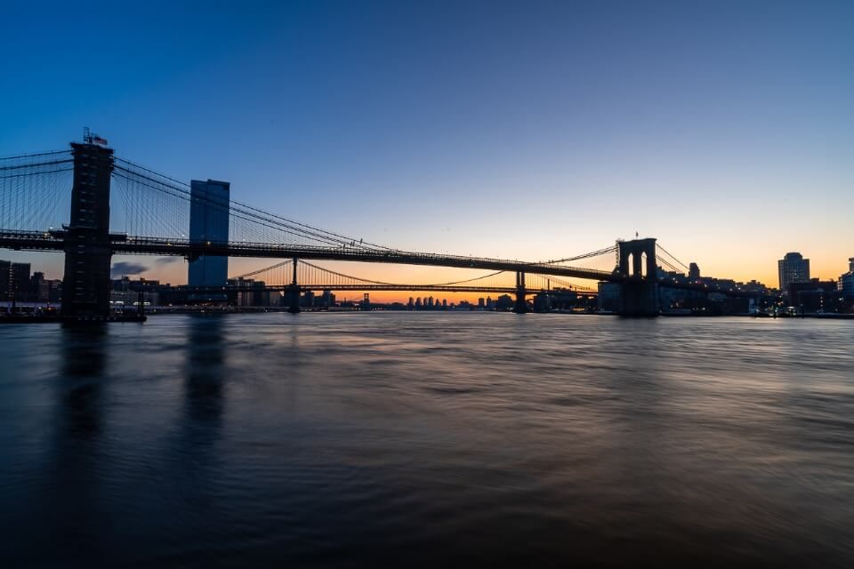 Brooklyn Bridge as seen from Pier 17 at sunrise in New York City