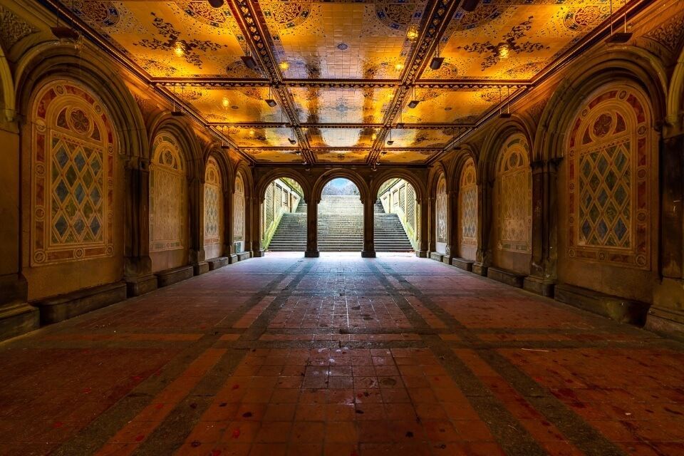 Bethesda Terrace glowing orange with a reflecting tiled ceiling making it one of the best nyc photography locations