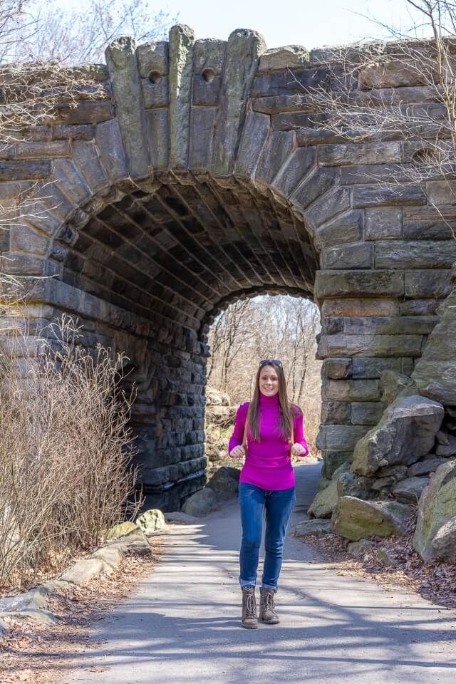 Woman in front of the Glen Span Arch in north central park on a warm winters days