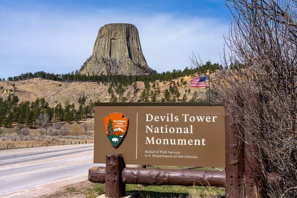 Entrance to national monument in wyoming sign and rock formation in background