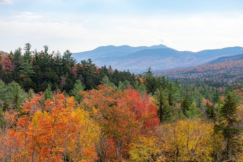 Beautiful vibrant fall foliage kancamagus highway road trip NH lincoln to conway scenic byway filled with red orange yellow green trees