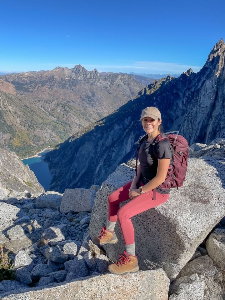 Kristen at the top of Aasgard Pass sat on a rock enjoying sunlight