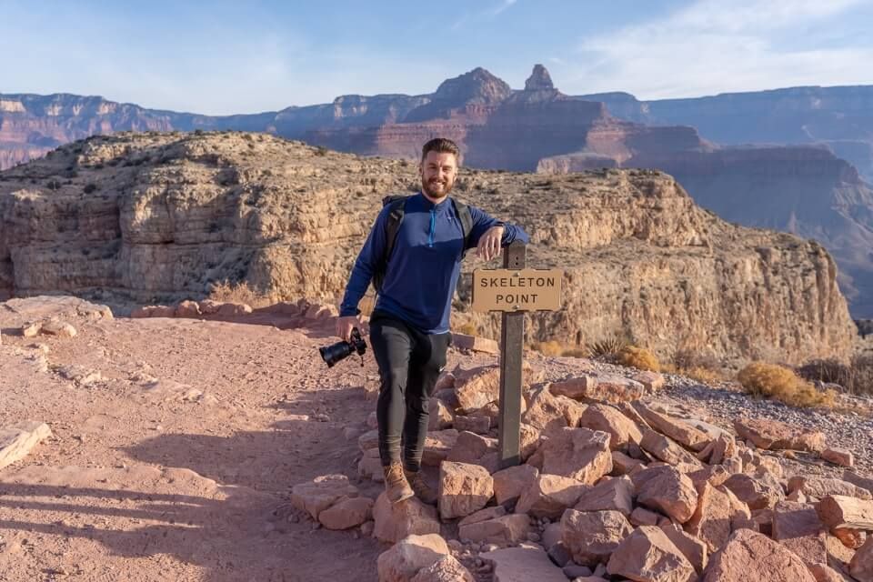 Hiker with camera at skeleton point on south kaibab trail one of the best day hikes in grand canyon south rim