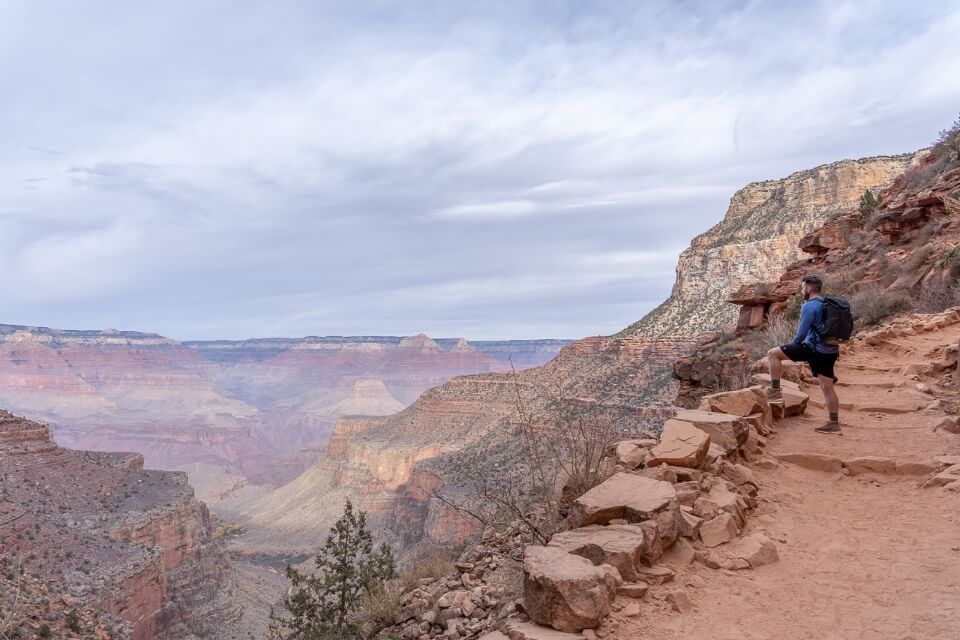 Hiker stopping to enjoy views over bright angel after day hiking south kaibab to phantom ranch