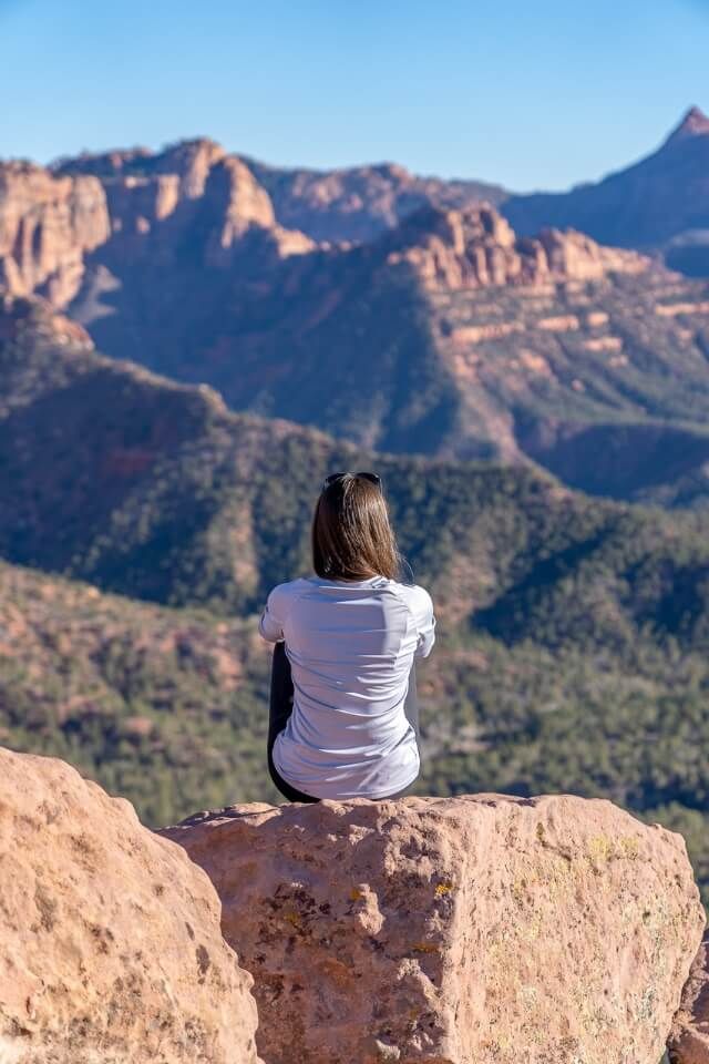 Hiker enjoying the view over Kolob Terrace and Kolob Canyon on a warm winter day in Utah