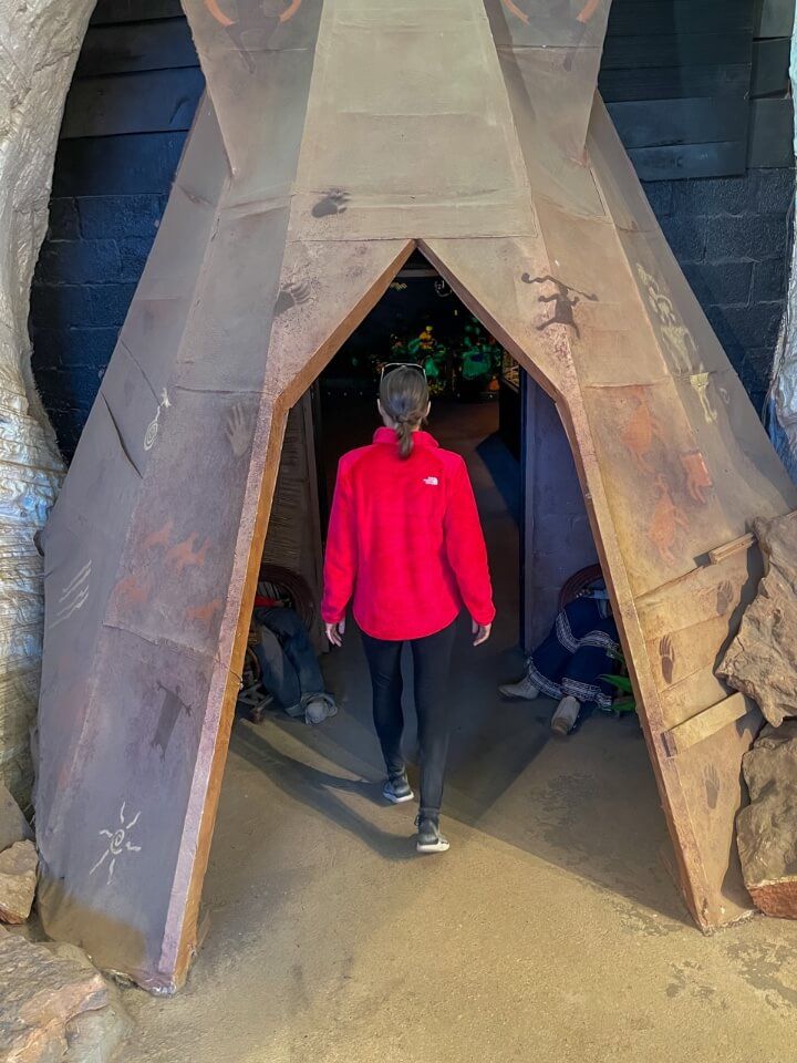 Walking through a teepee inside Moqui Cave to enter the concert hall room