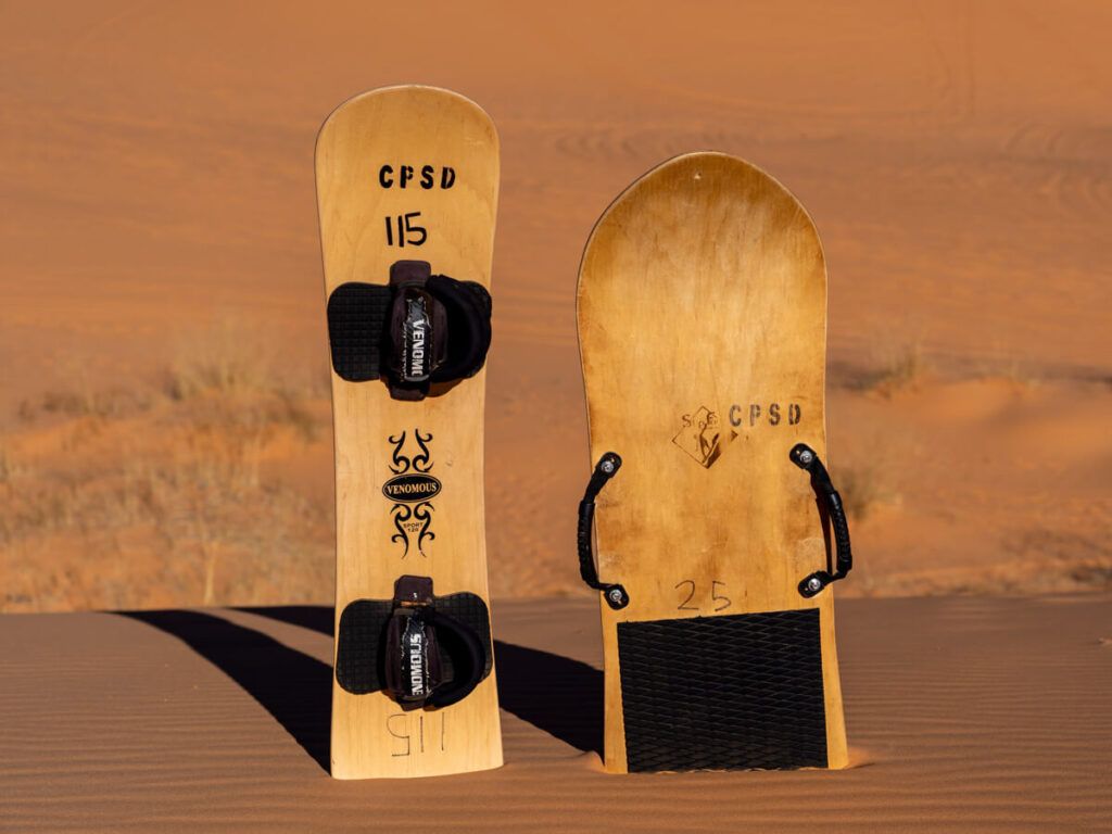 Sandboards stuck in sand dunes at sunset in the desert