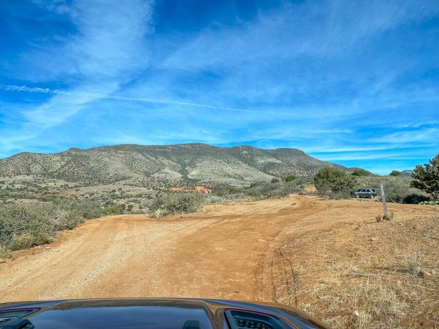 Parking area for 2WD cars on a dirt road taken from inside a Jeep