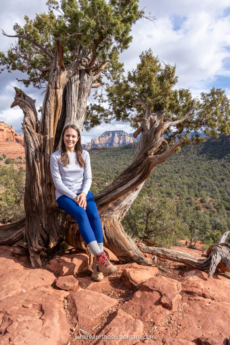 Hiker in grey t shirt and blue pants sat on a tree at the boynton canyon vortex in sedona