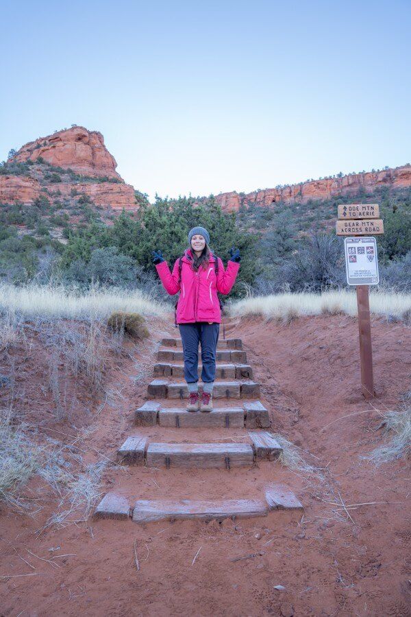 Hiker in winter coat on stone steps at the start of a hike in arizona