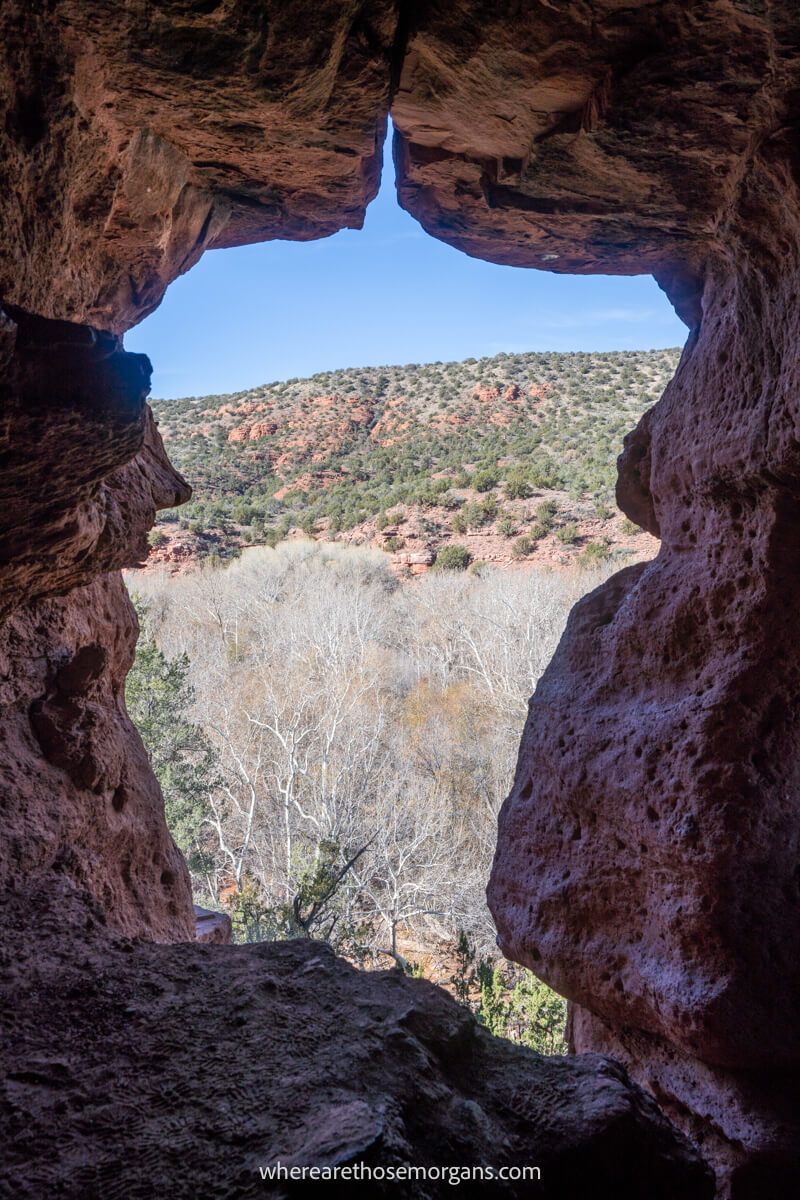 View through a cavern opening over a steep hill