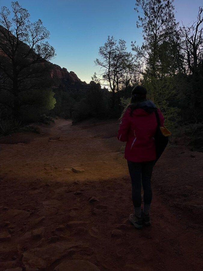 Hiker with headlamp hiking at dawn in arizona