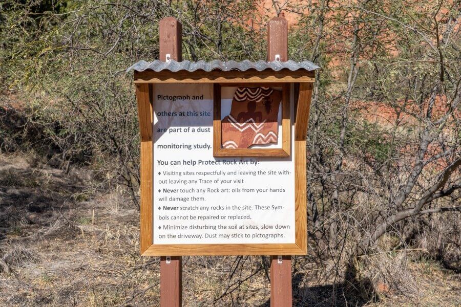 A wooden sign telling visitors how to act at the heritage site