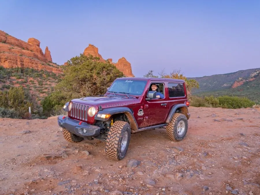 Driving a 4WD Rubicon on a dirt track with purple sky at dusk in arizona