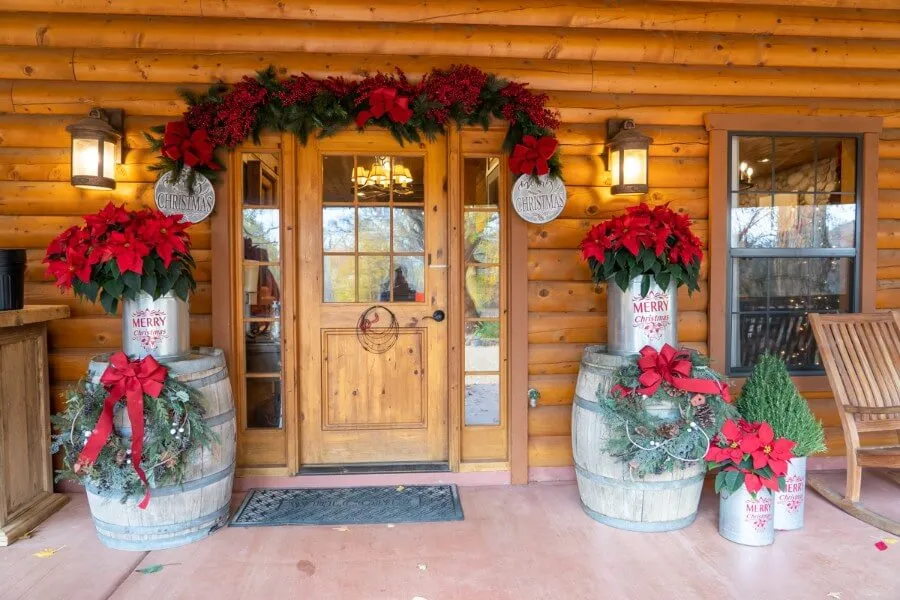 A wooden building with numerous Christmas decorations by the entrance