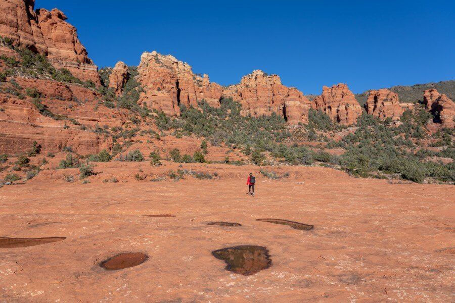 Hiker walking on Cow Pies red rock formation