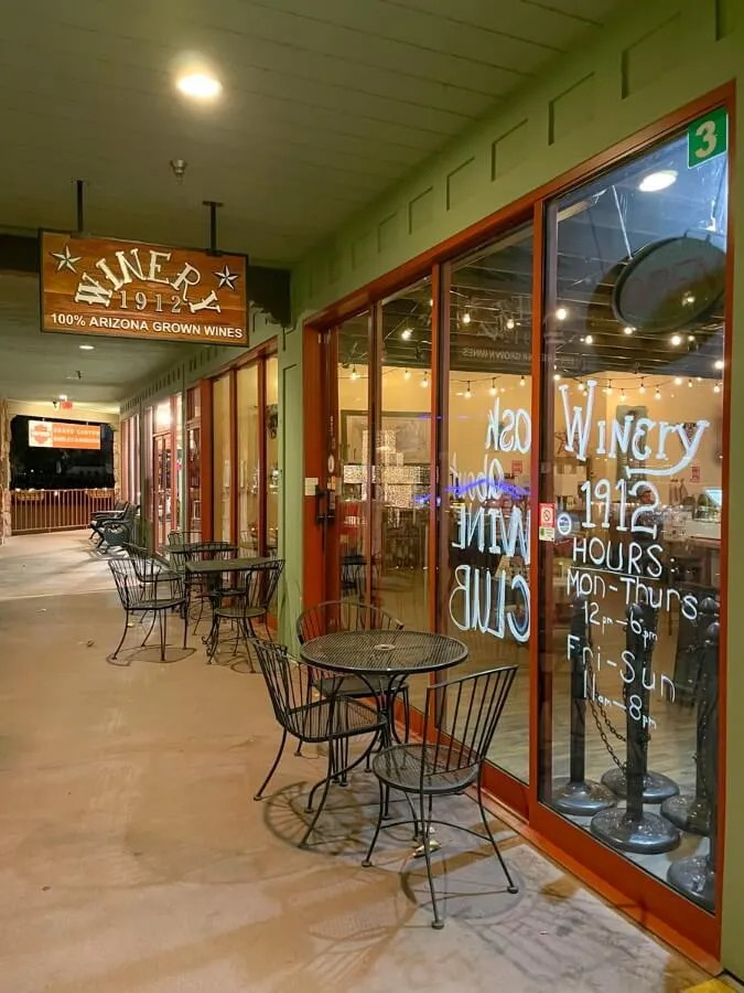 Outside storefront of Winery 1912 with empty tables in winter time