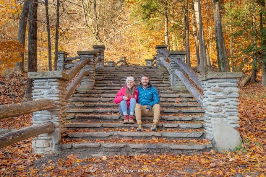 Man and woman sitting on stone steps near Upper falls at Letchworth State Park