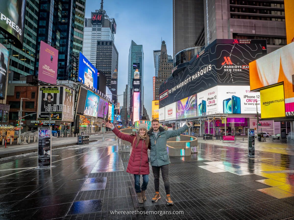 Man and woman standing in the middle of Time Square with no crowd
