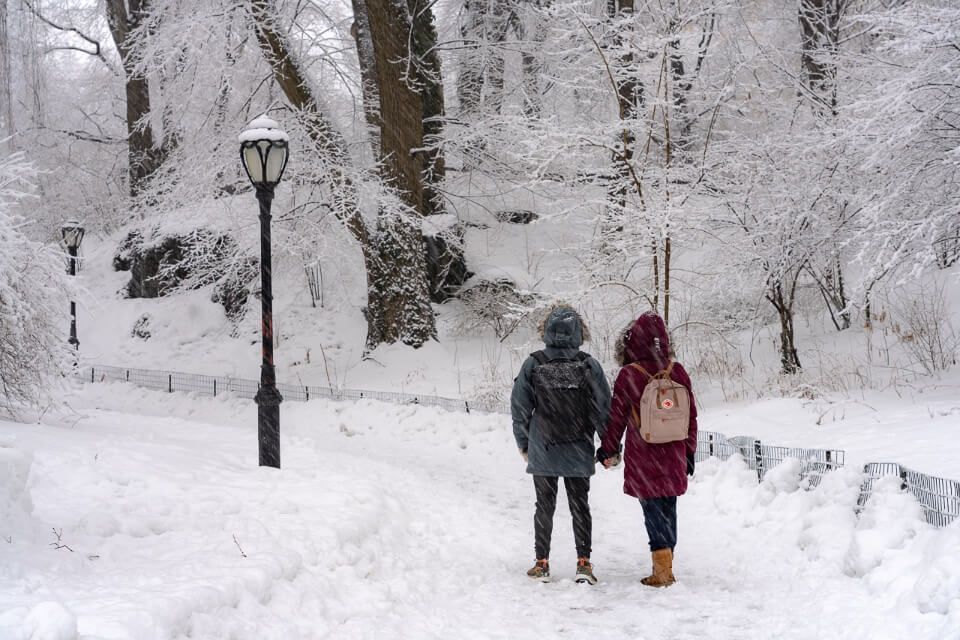 Couple walking in the snow at Central Park in New York City