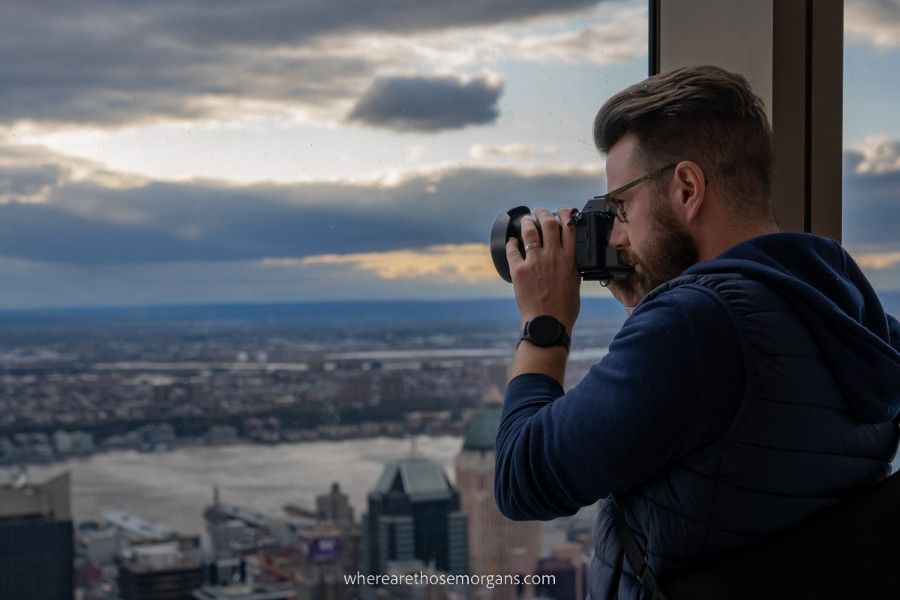 Man looking out the window of SUMMIT One Vanderbilt to take a photo