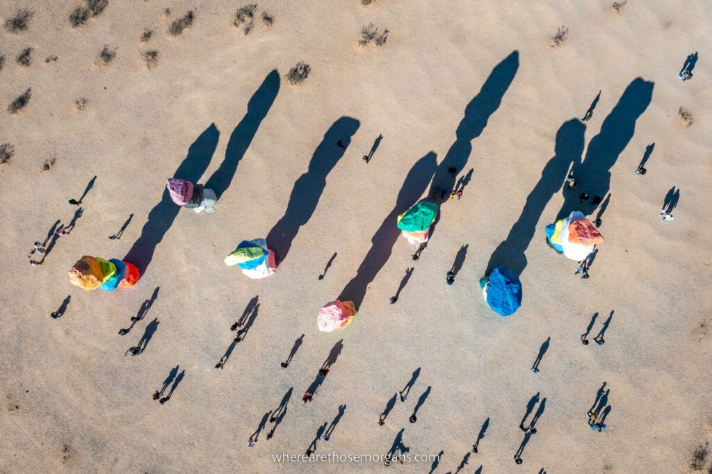 Birds eye view drone photo of Seven Magic Mountains from directly above with crowds and shadows near Las Vegas